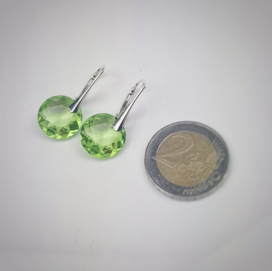 Close-up of Round Diamond-Shaped Peridot Crystal Drop Earrings with leverback hooks displayed next to a €2 coin for size reference.