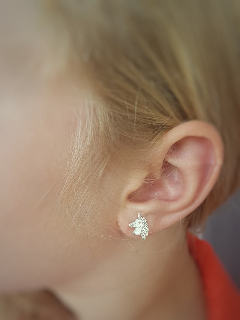 Close-up of a teenage girl wearing Unicorn Silver Stud Earrings, highlighting the intricate details, made by Magpie Gems in Ireland